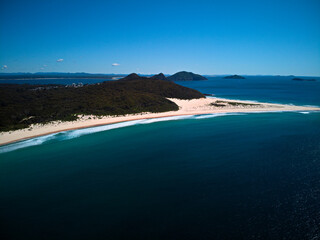 Fototapeta premium Drone photo of Fingal Bay and the spit leading to Shark Island on a bright sunny day
