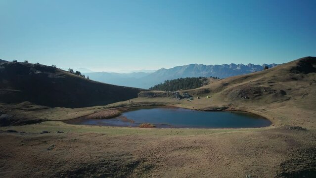 A drone tracks back the dragonlake of mountain Smolikas at 2.200m altitude