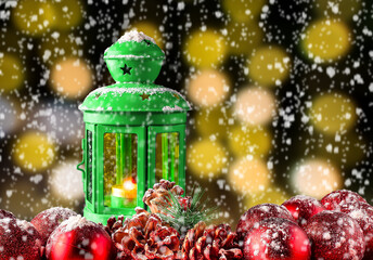 Christmas lantern on snow with red balls and blurred Xmas lights - Holiday background