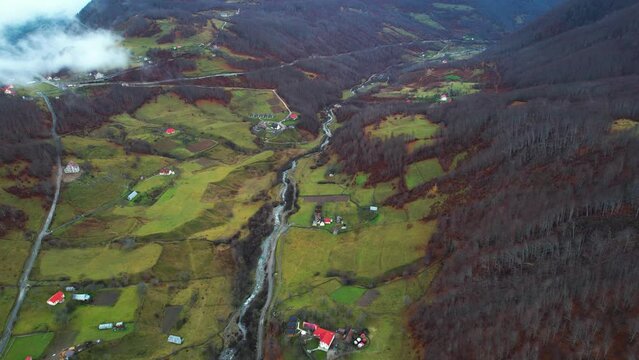 Colorful countryside landscape in Albanian Alps, houses and meadows surrounded by Autumn colors of mountains