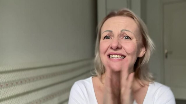 Woman receives good news Opening her mouth and eyes wide claps her hands happy eyebrows rise and delight on her face covers hands and laughs Is it really so lucky to win Product advertisement