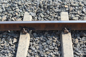 Railway lines with track ballast. Train tracks underlay, rails and crushed stones. Industrial landscape. Railway junction.