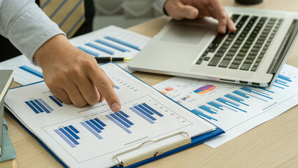 Young businessman working at office with financial documents, laptop, calculator on table Planning...