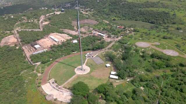 Slow aerial view of the waving Mexico Independence Declaration flag above Iguala