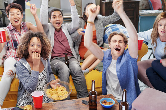 Food, party and watching tv with friends in living room for sports games, winner and goal with global Fifa world cup. Diversity, support and wow with soccer fans for television, news and broadcast