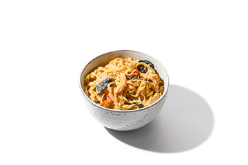 Asian fried noodles with chicken in creamy garlic sauce isolated on white background Chinese fried noodles in creamy sauce in ceramic bowl. Stir-fry udon with chicken in minimal style. Wok menu