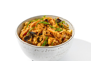 Asian fried noodles with shiitake mushrooms and vegetables isolated on white background Chinese fried noodles in vegetarian style in ceramic bowl. Stir-fry udon with vegetables and mushrooms