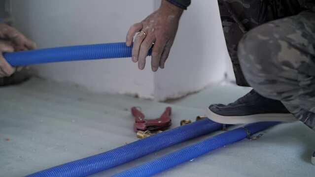 plumbers lay tubes in the apartment