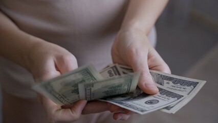 Close-up male hands consider paper dollars. A man thinks about where to invest the accumulated money in order to receive good dividends when he retires