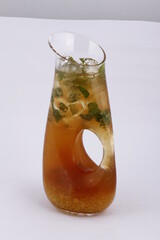 Iced tea pitcher with mint leaves and lemon pulp