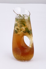 Iced tea pitcher with mint leaves and lemon pulp