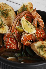 Seafood pot with lobster, crab, mussels, lemon and garlic bread