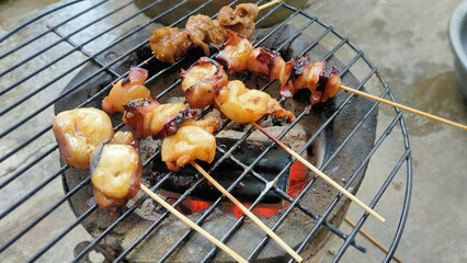 Fresh squid on skewers and grilled over charcoal for seafood and barbecue.