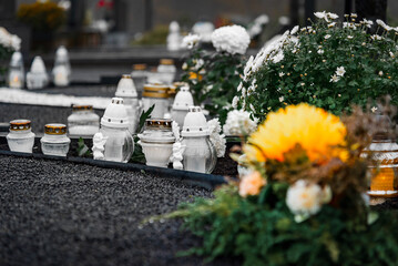 All Saints' Day and burning candles and flowers on the graves.Candles on graves symbolize the memory of the dead on November 1.Catholic cemetery during All Saints' Day.Selective focus.