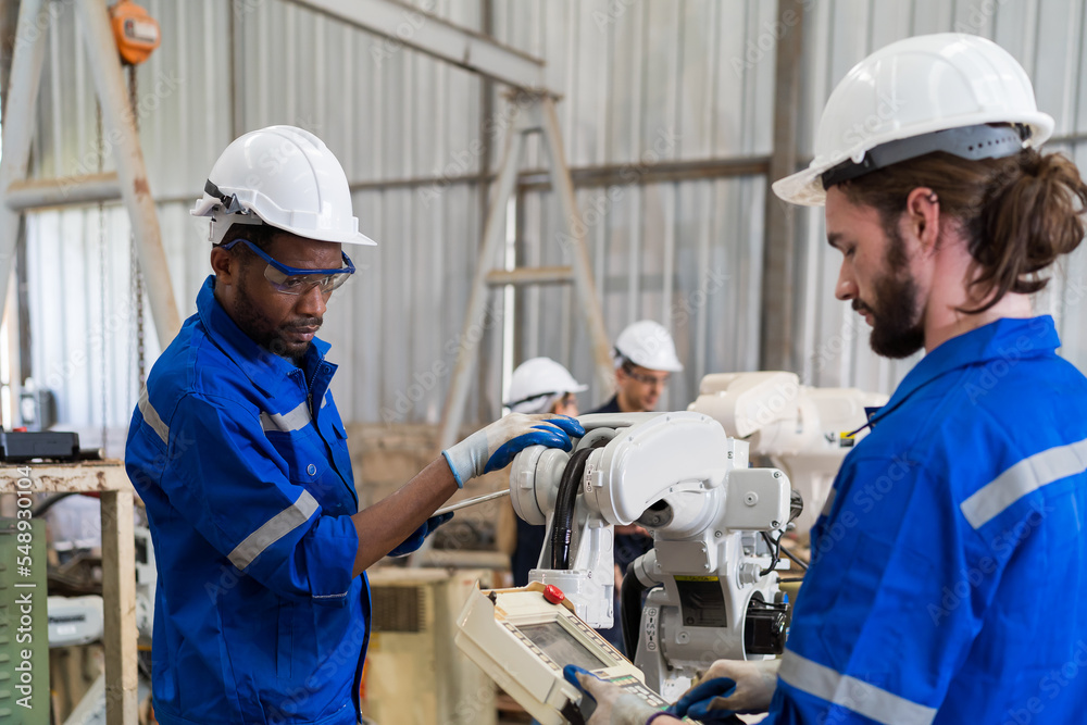 Fototapete group of factory male engineer worker working with adept robotic arm in workshop. male engineer main
