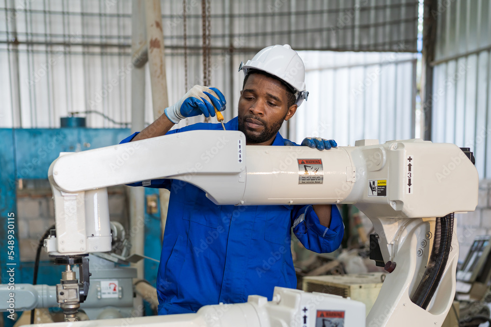 Leinwandbilder factory male engineer worker working with adept robotic arm in workshop. male engineer maintenance a