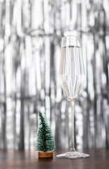 Christmas tree and glass of champagne on silver background with copy space. Merry xmas and Happy...