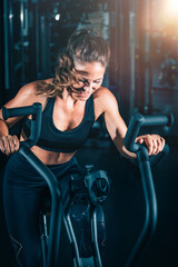 Obraz na płótnie Canvas Woman Exercising on Air Bike in the Gym.