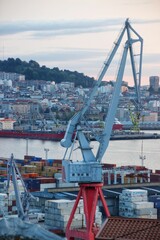 Vertical crane for loading and unloading with buildings and trees in the port of Vigo, Spain