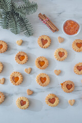 sweet home made linzer christmas cookies filled with apricot jam on a table