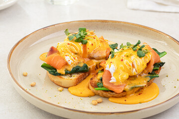 Portion of eggs benedict toast with salmon and herbs breakfast