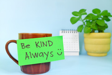 Be kind always motivation and inspiration kindness concept. Selective focus of a cup of coffee with handwritten bright paper note.