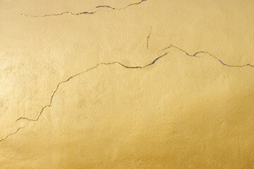 Cracks on surface of golden cement statue background