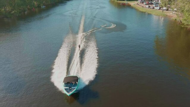 Aerial view of riding speedboat and waterski on waters. Drone shot. 