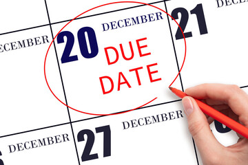 Hand writing text DUE DATE on calendar date December 20 and circling it. Payment due date