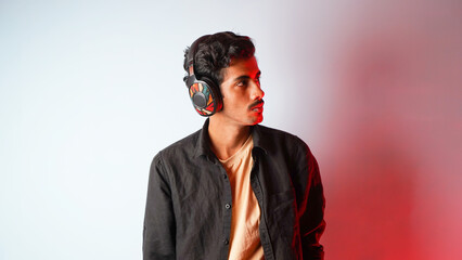Obraz premium Young man listening to music isolated over colour background, chilling and enjoying music, headphones music concept