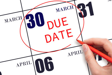 Hand writing text DUE DATE on calendar date March 30 and circling it. Payment due date