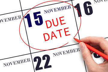 Hand writing text DUE DATE on calendar date November 15 and circling it. Payment due date
