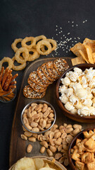 Assortment of salty snacks on dark background.