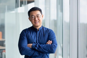 Portrait of successful mature boss, senior businessman in glasses Asian looking at camera and...