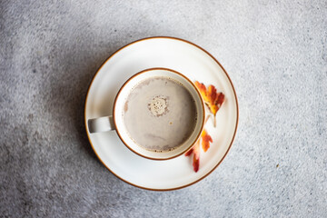 Overhead view of a cup of coffee with milk and autumnal leaf decorations