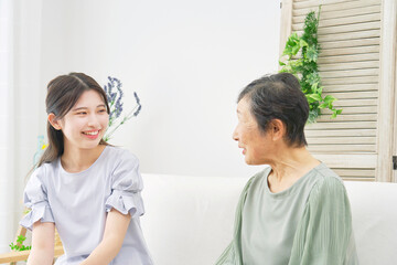Obraz na płótnie Canvas 家で会話をする孫と祖母