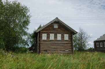 Abandoned wooden houses in the Russian village. grassy street