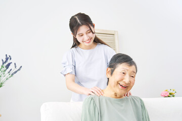 Fototapeta premium 祖母の肩揉みをする孫