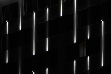 Dark facade at night with lines illumination pattern
