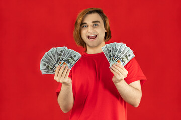 Emotional young man with cash. Guy with currency banknotes. The concept of a successful money story, start-up, student loan, part-time job, winning