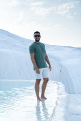 Man happy posing with sunken feet in the thermal pools of pamukkale.