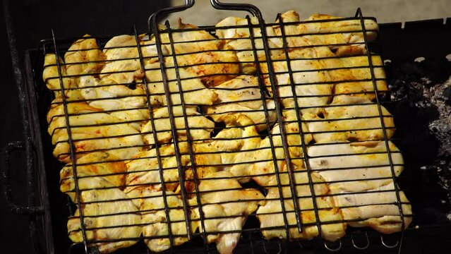 close-up of flattened out barbecued golden crispy skin chicken tabaka on grid, side view from above