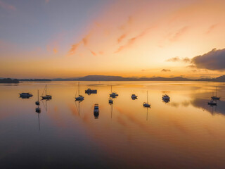 Sunrise over the water with fog, boats, clouds and reflections