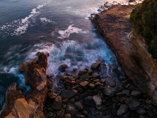 Top down sunrise over the ocean with rocks