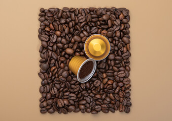Coffee capsules on square coffee beans texture on beige background with ground coffee