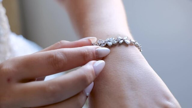 Closeup Woman Hand Adjusting Jewelry Bracelet. Bride Adjusting The Bracelet While Wearing A Beautiful White Wedding