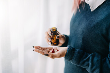 woman hand holding bottle with pills on hand going to take medicaments prescribed by his physician