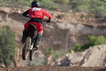 Racer boy on motorcycle participates in motocross race, active extreme sport. Photographed while jump