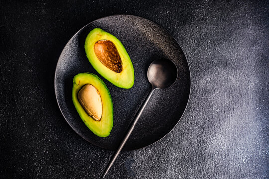Overhead view of a halved avocado on a plate