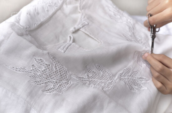 Close-Up of a woman making an embroidered cotton unisex tunic, Indonesia